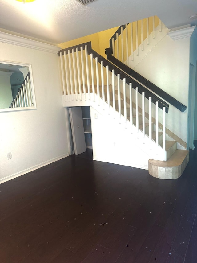 staircase featuring hardwood / wood-style flooring and crown molding