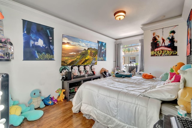 bedroom with hardwood / wood-style floors and ornamental molding