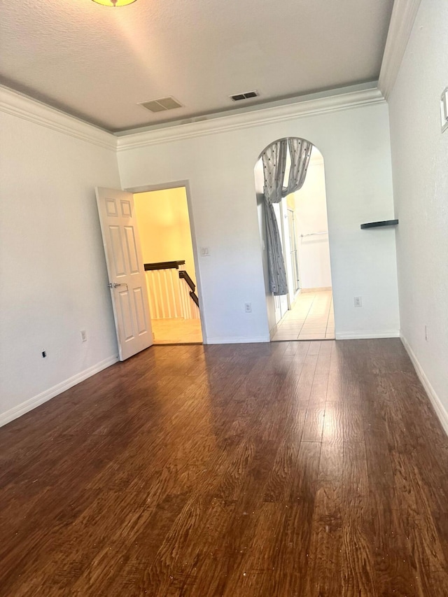 spare room with crown molding and hardwood / wood-style flooring