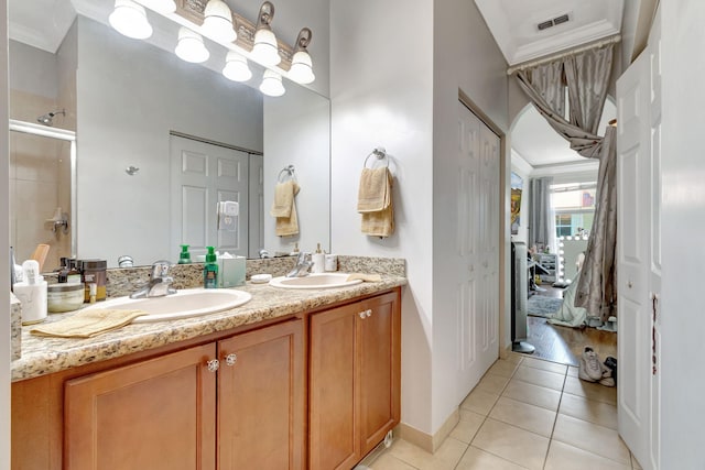 bathroom with vanity, tile patterned floors, ornamental molding, and walk in shower