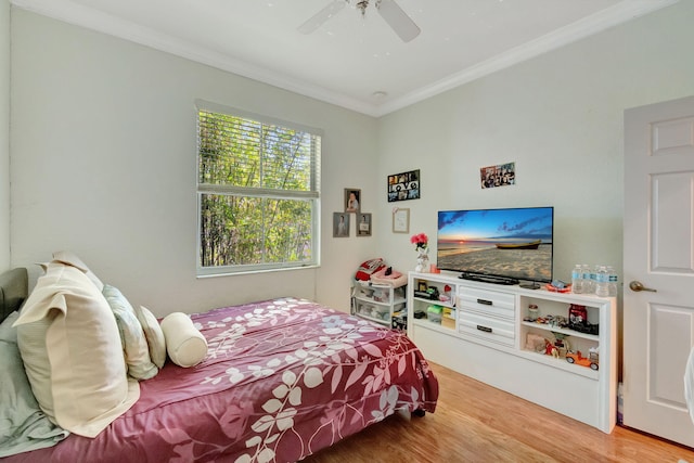 bedroom with crown molding, ceiling fan, and wood-type flooring