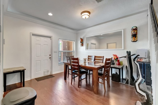 dining space featuring crown molding and hardwood / wood-style flooring