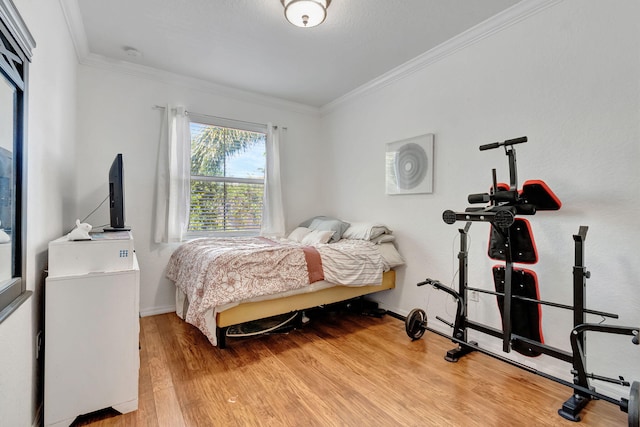 bedroom with hardwood / wood-style flooring and crown molding