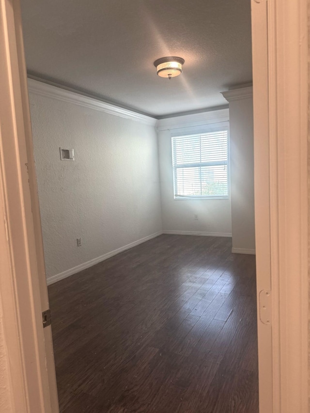 empty room featuring crown molding and dark hardwood / wood-style floors