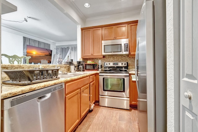 kitchen with crown molding, tasteful backsplash, light stone counters, light hardwood / wood-style flooring, and stainless steel appliances