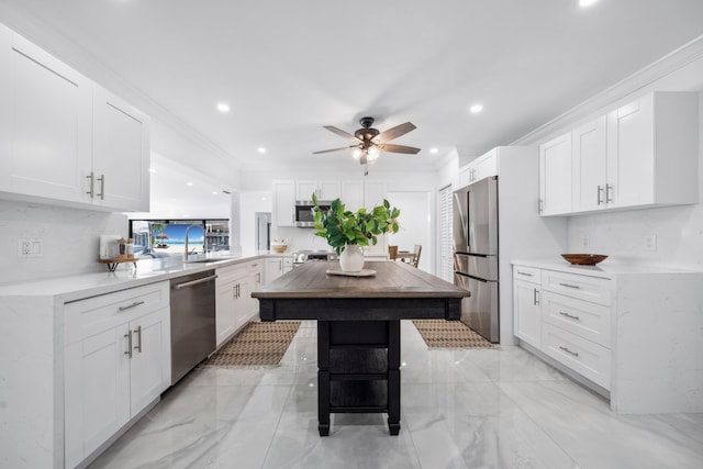 kitchen featuring white cabinetry, stainless steel appliances, kitchen peninsula, a breakfast bar, and ornamental molding