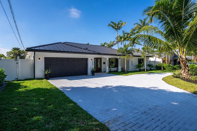 view of front of property featuring a garage and a front lawn