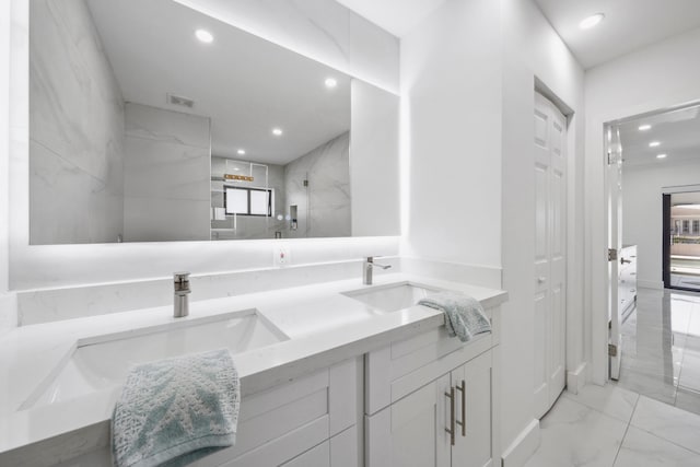 bathroom featuring a tile shower and vanity