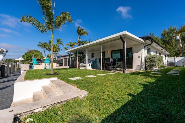 back of house with a yard and a patio