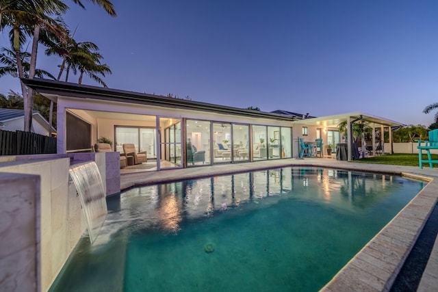 pool at dusk featuring a patio