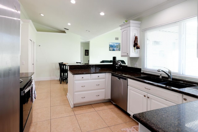 kitchen featuring stainless steel appliances, white cabinetry, lofted ceiling, and sink