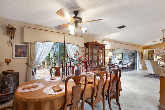 tiled dining area with ceiling fan, ornamental molding, and a textured ceiling