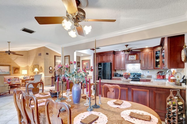 tiled dining area featuring a textured ceiling, ornamental molding, and sink