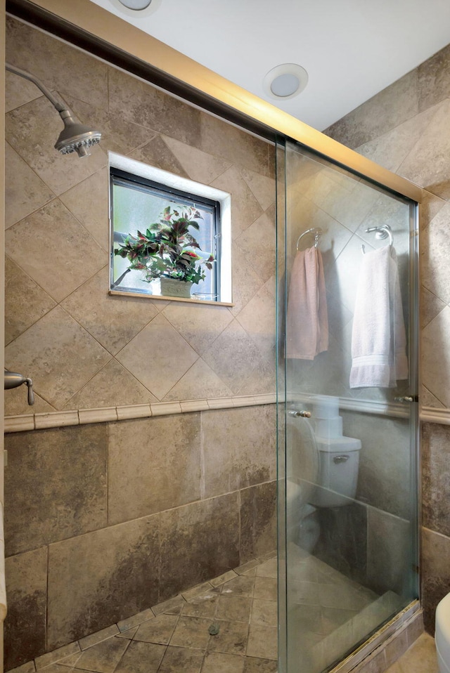 bathroom featuring toilet and an enclosed shower