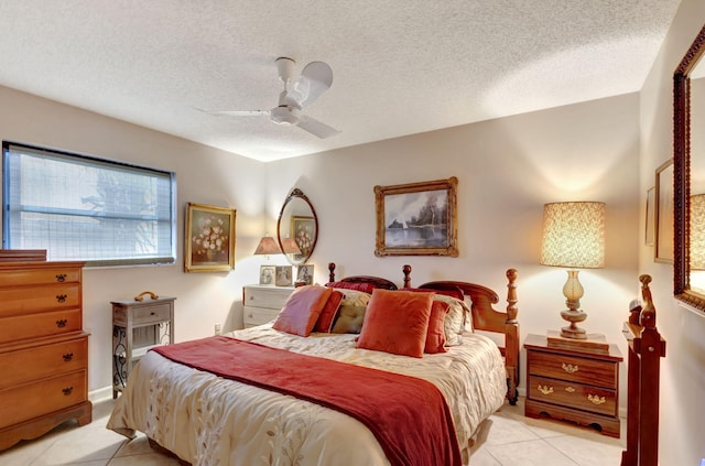 tiled bedroom with ceiling fan and a textured ceiling