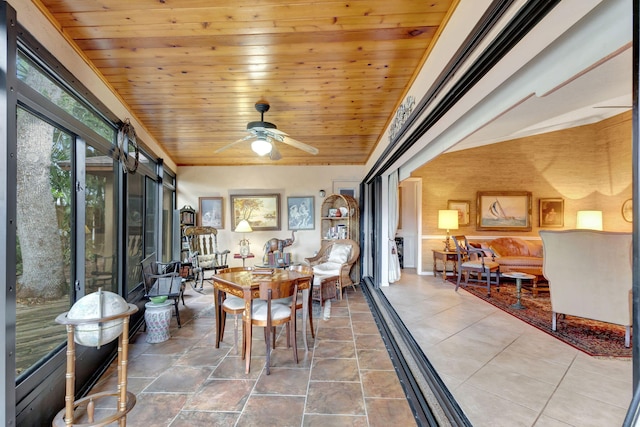 sunroom / solarium featuring ceiling fan, a barn door, and wooden ceiling