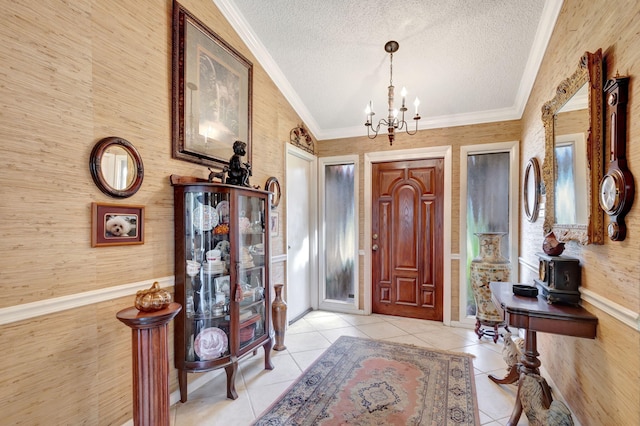 foyer with a textured ceiling, crown molding, a chandelier, and lofted ceiling