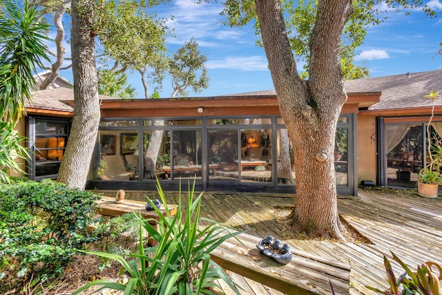 back of property featuring a sunroom and a wooden deck