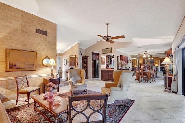 tiled living room with a textured ceiling, high vaulted ceiling, ceiling fan, and crown molding