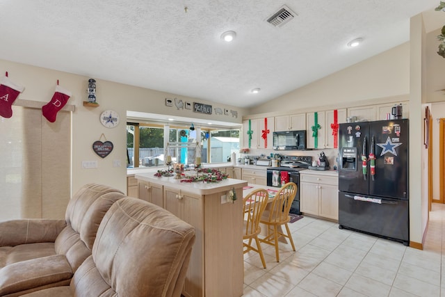 kitchen featuring black appliances, a center island, a textured ceiling, and vaulted ceiling