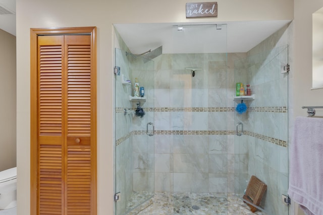 bathroom with toilet and an enclosed shower