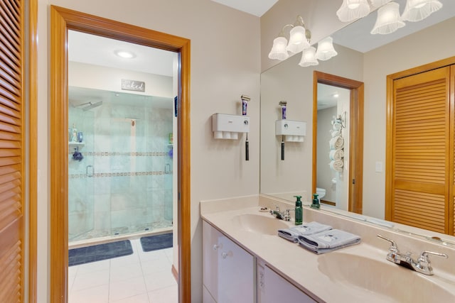 bathroom featuring tile patterned floors, vanity, toilet, and a shower with door