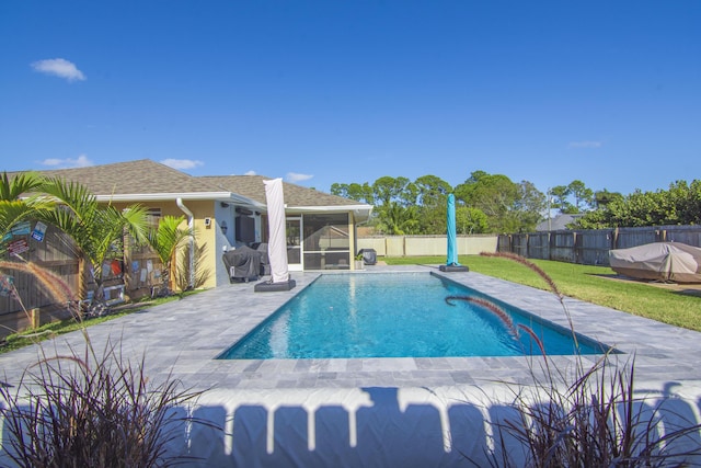 view of pool featuring a lawn, a sunroom, and a patio