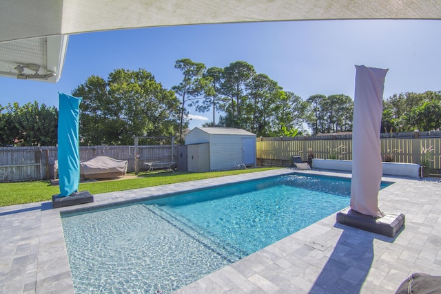 view of pool with a lawn, a shed, and a patio