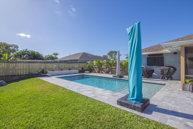 view of swimming pool with grilling area and a lawn