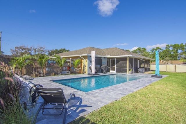 view of pool with a lawn, a patio area, and a sunroom