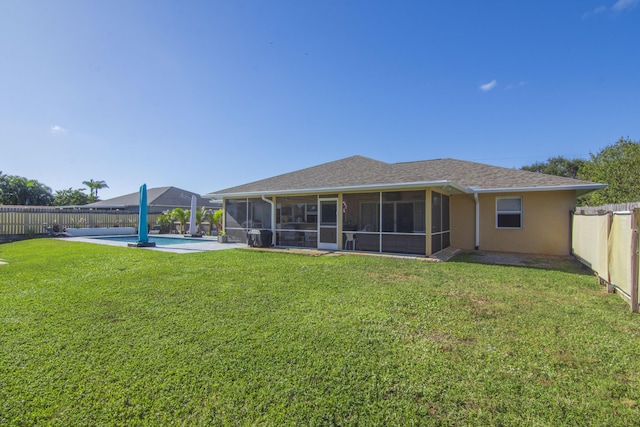 back of property featuring a yard, a fenced in pool, and a sunroom