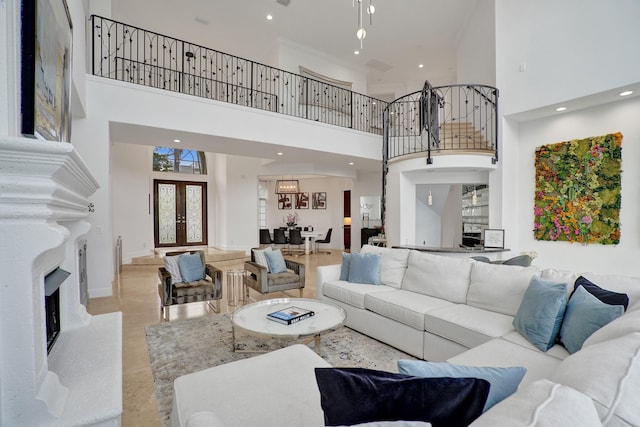 living room with a fireplace, french doors, and a high ceiling