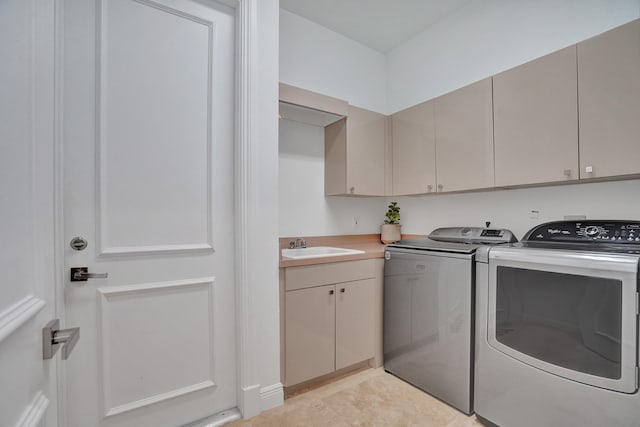 washroom featuring cabinets, washer and dryer, and sink