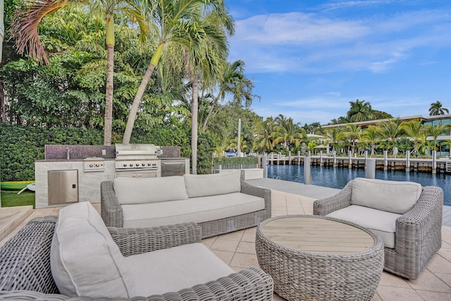 view of patio with area for grilling, outdoor lounge area, sink, a water view, and a grill