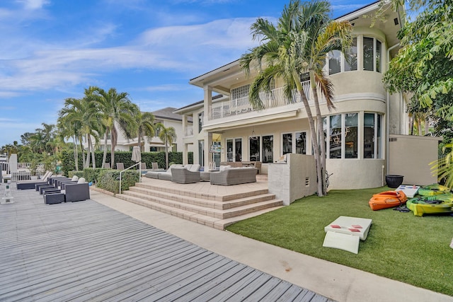 back of property featuring a yard, a patio area, a balcony, and an outdoor hangout area