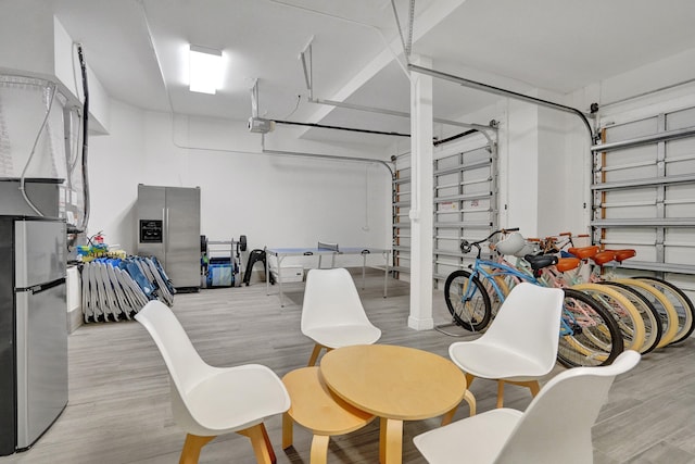 garage featuring stainless steel fridge, stainless steel fridge with ice dispenser, and a garage door opener