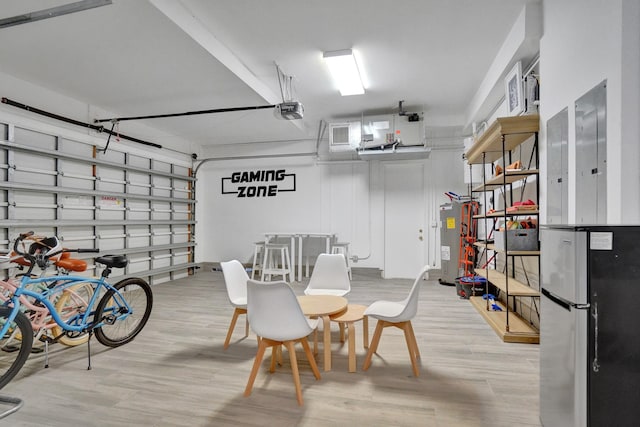 garage featuring electric water heater, a garage door opener, and stainless steel refrigerator