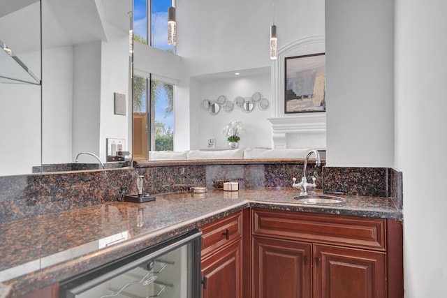 kitchen with decorative light fixtures, beverage cooler, and sink