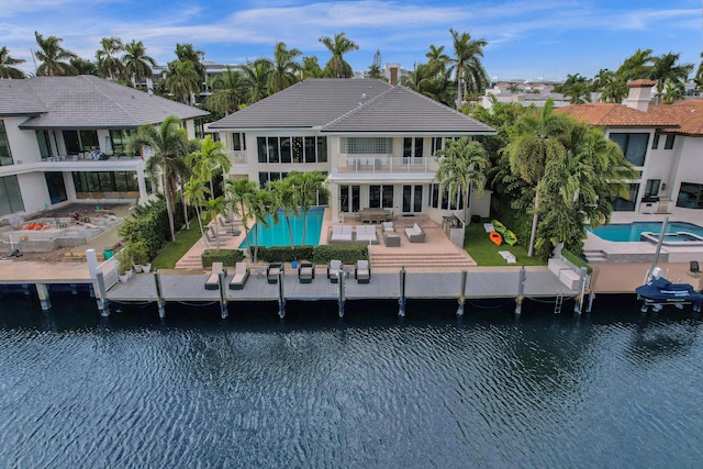 back of house with a patio area, a water view, and a balcony