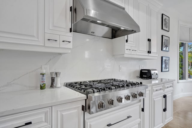 kitchen with white cabinetry, extractor fan, and stainless steel gas stovetop