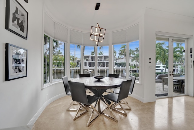 dining space featuring a water view and a notable chandelier