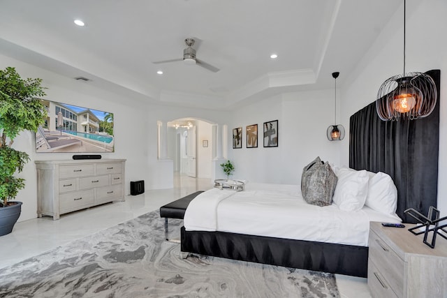 bedroom featuring a tray ceiling, ceiling fan, and ornamental molding