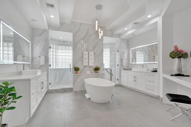 bathroom featuring plus walk in shower, vanity, tile patterned floors, and tile walls