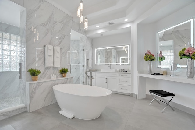 bathroom featuring plus walk in shower, vanity, and tile walls