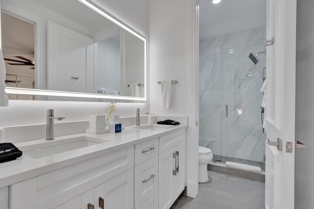 bathroom with a shower with door, vanity, and toilet