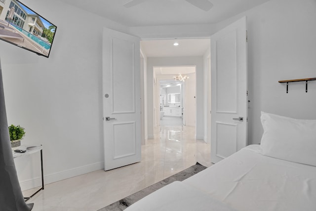 bedroom featuring ceiling fan with notable chandelier