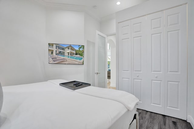 bedroom featuring dark hardwood / wood-style flooring, a closet, and ornamental molding