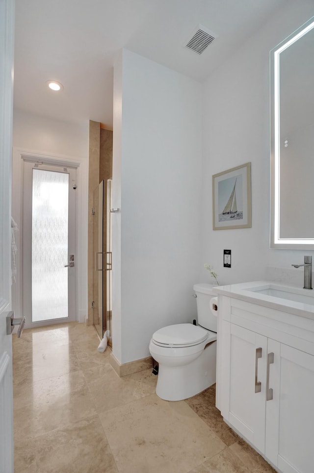 bathroom featuring tile patterned flooring, vanity, toilet, and a shower with shower door