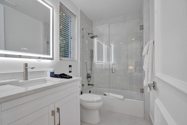 full bathroom featuring tile patterned floors, toilet, combined bath / shower with glass door, and vanity