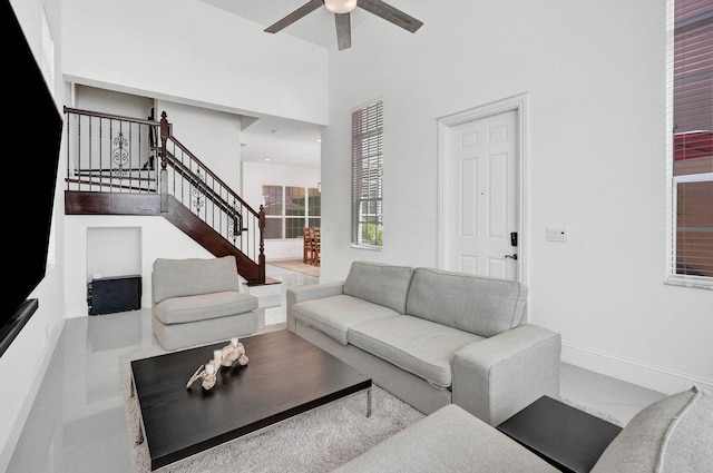 living room featuring ceiling fan and a towering ceiling